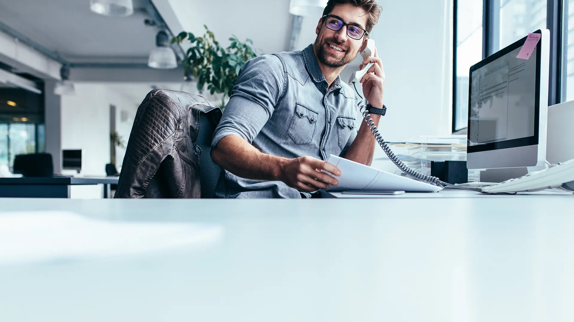 Ein Makler telefoniert in seinem Büro