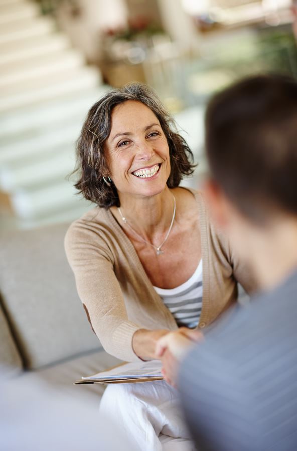 Eine freundliche Frau unterhält sich mit einem Mann.