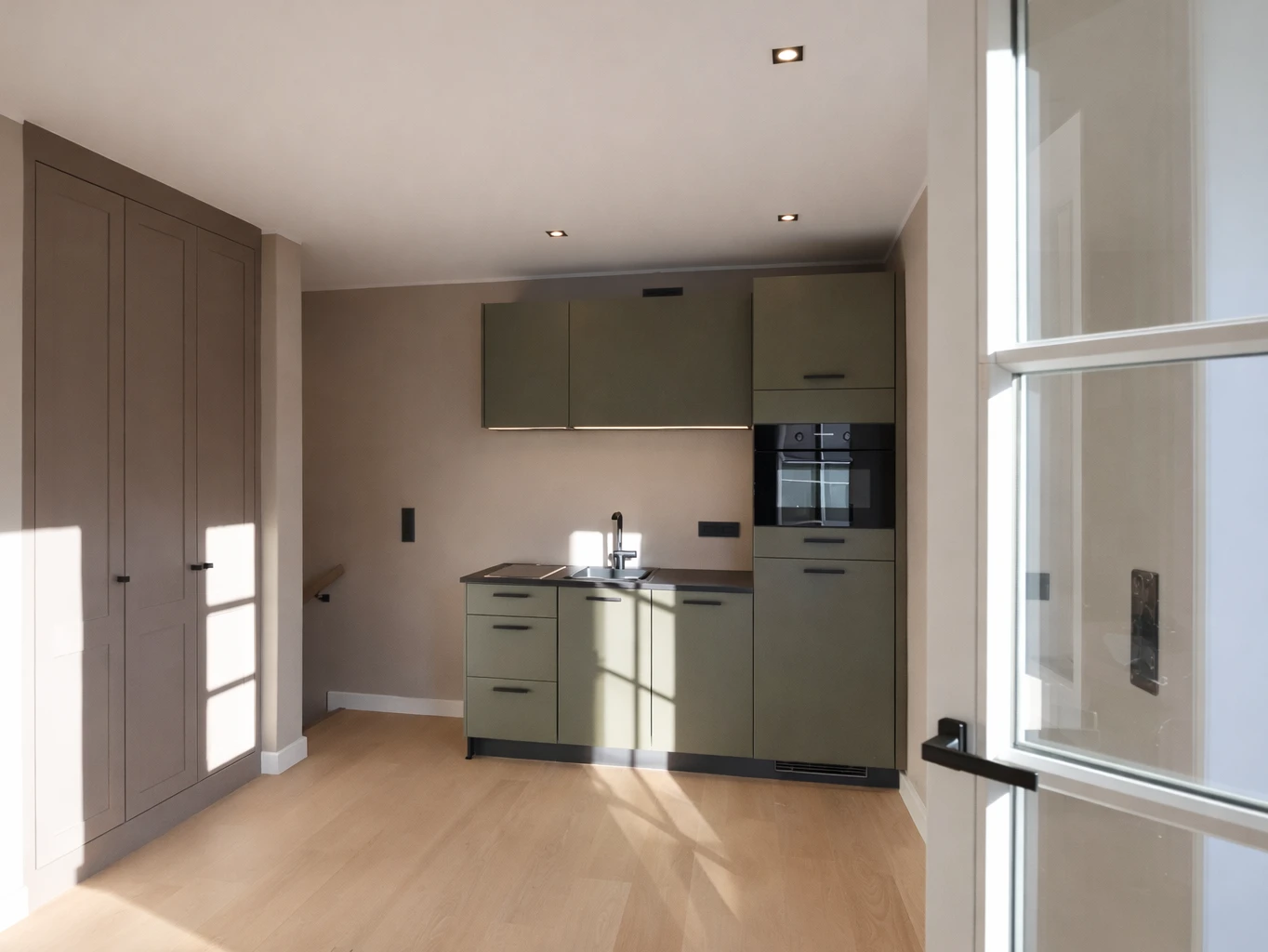 Küche mit grünen Schränken und hellen Holzfußböden. Moderne Einrichtung.