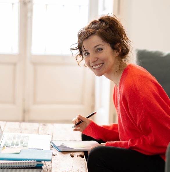 Eine lächelnde Frau mit einem Stift in der Hand