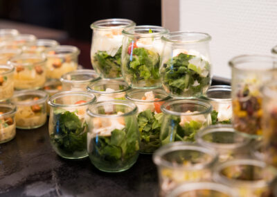 Ein Arrangement von Salaten in kleinen Gläsern. Die Salate bestehen aus verschiedenen Gemüsen.