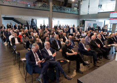 Ein Saal voller Männer in Anzügen, die auf Stühlen sitzen.