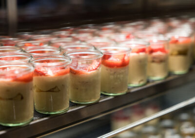 Ein Glas Dessert mit Früchten, cremiger Pudding.